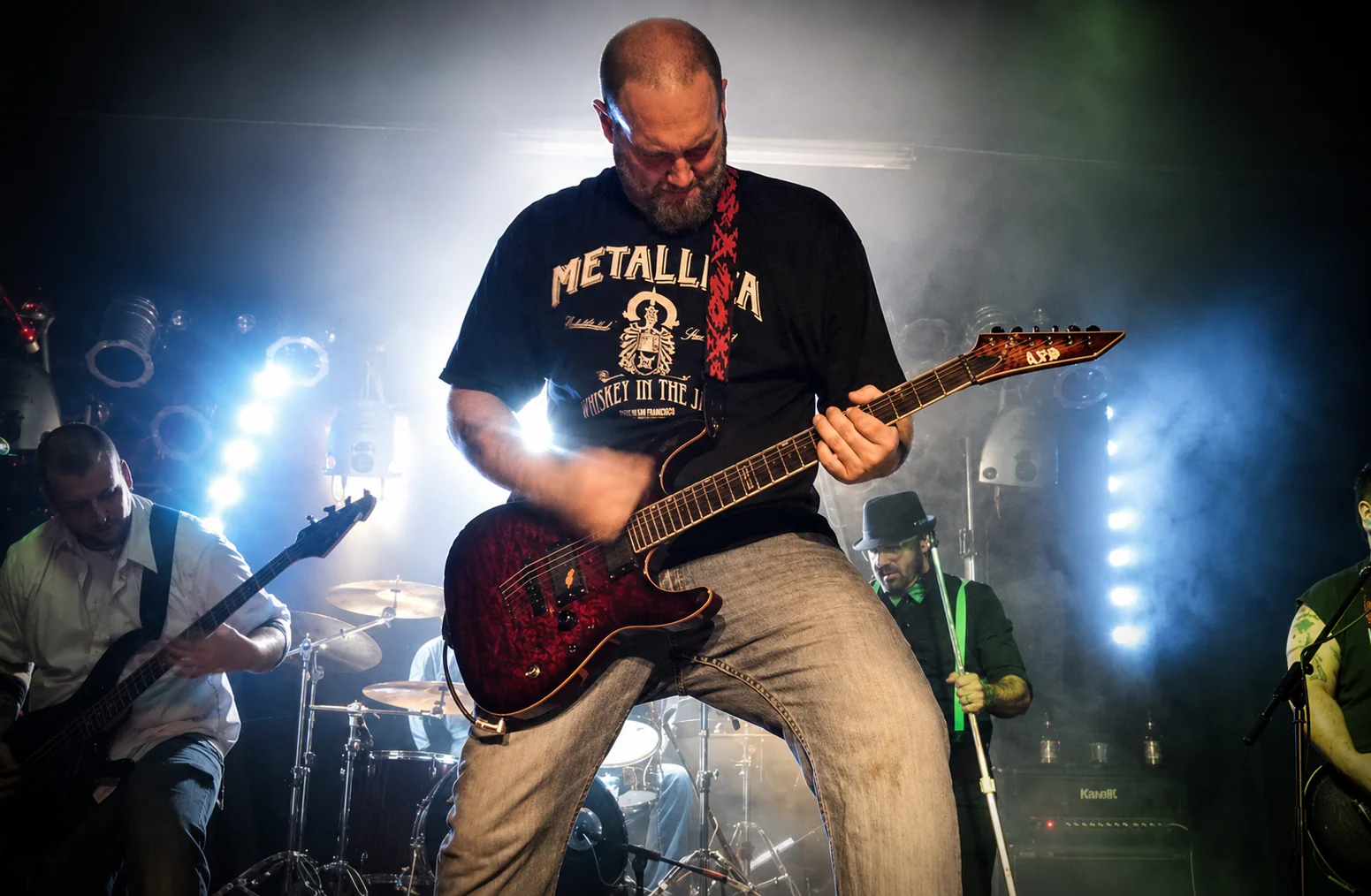 Dewey Wayne Harrell performing guitar beneath concert lights